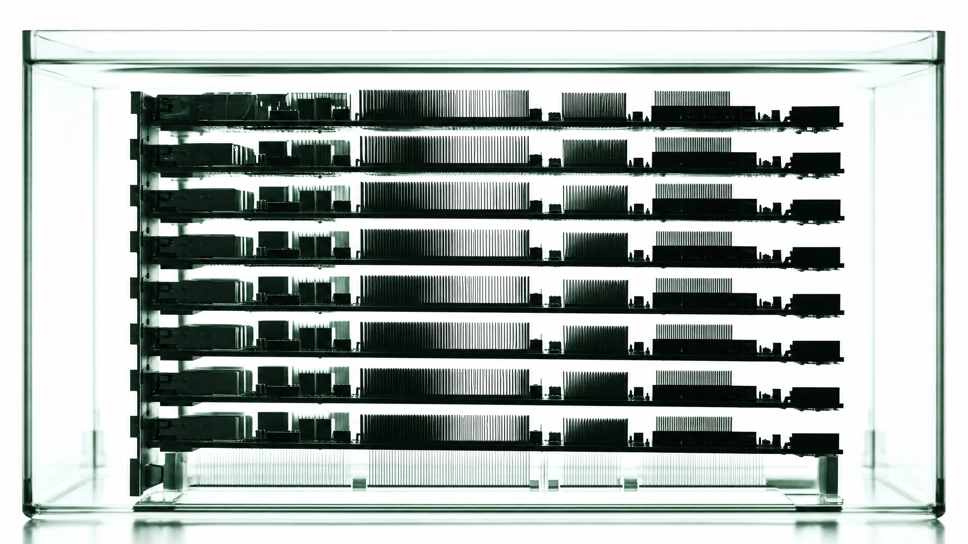 Eight server boards suspended in a glass bath of clear dielectric fluid, silhouetted against a blown-out backlight. Every board is passively cooled with bare finned heatsinks. The fluid surface is unbroken.